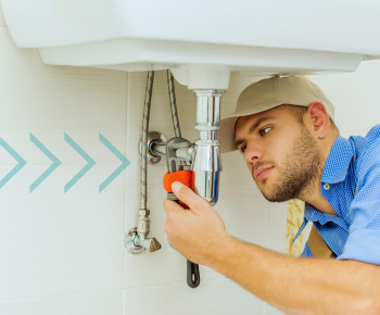 Man under sink fixing plumbing, arrows pointing to the issue